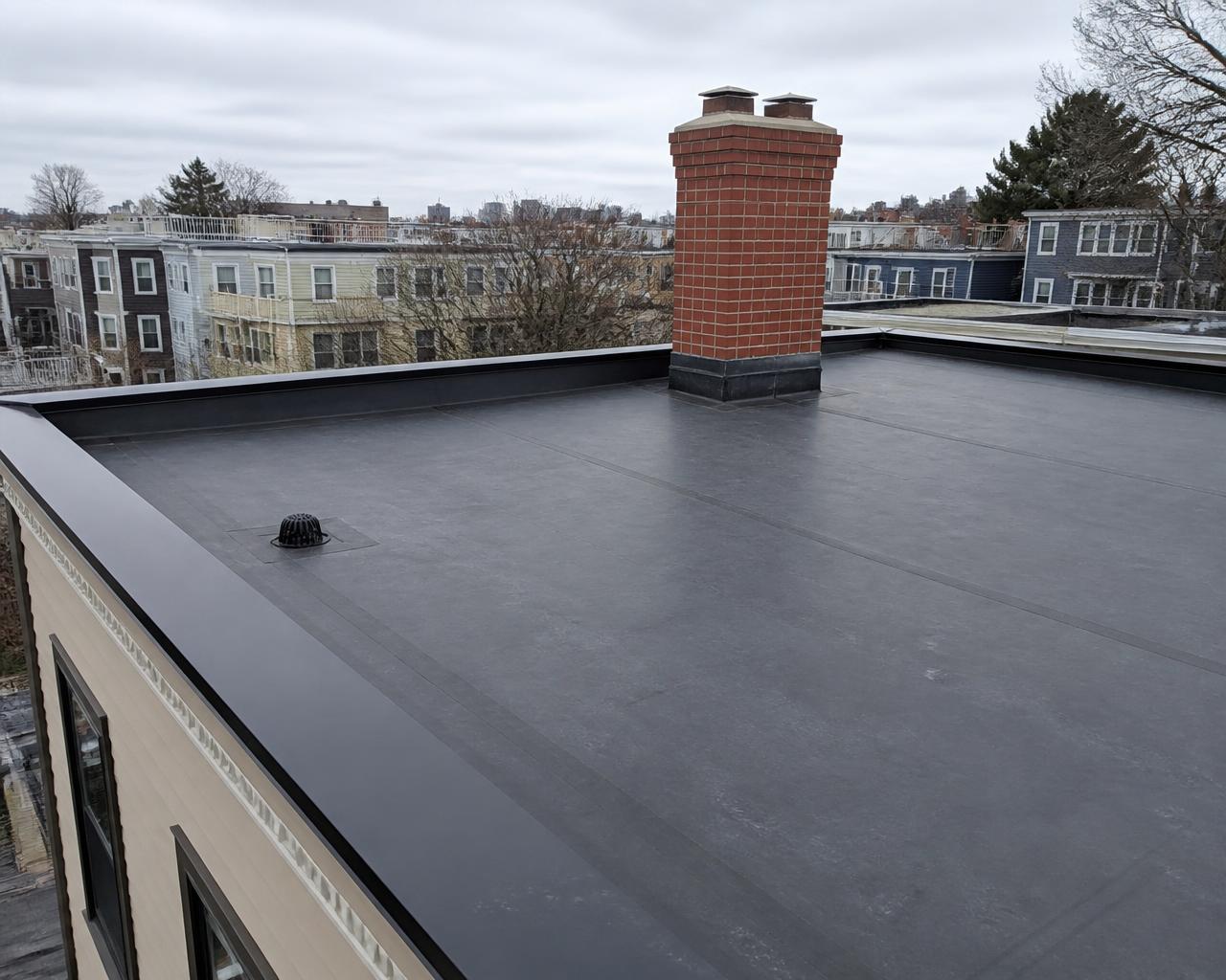Completed black EPDM flat rubber roof on a South Boston, MA three-decker